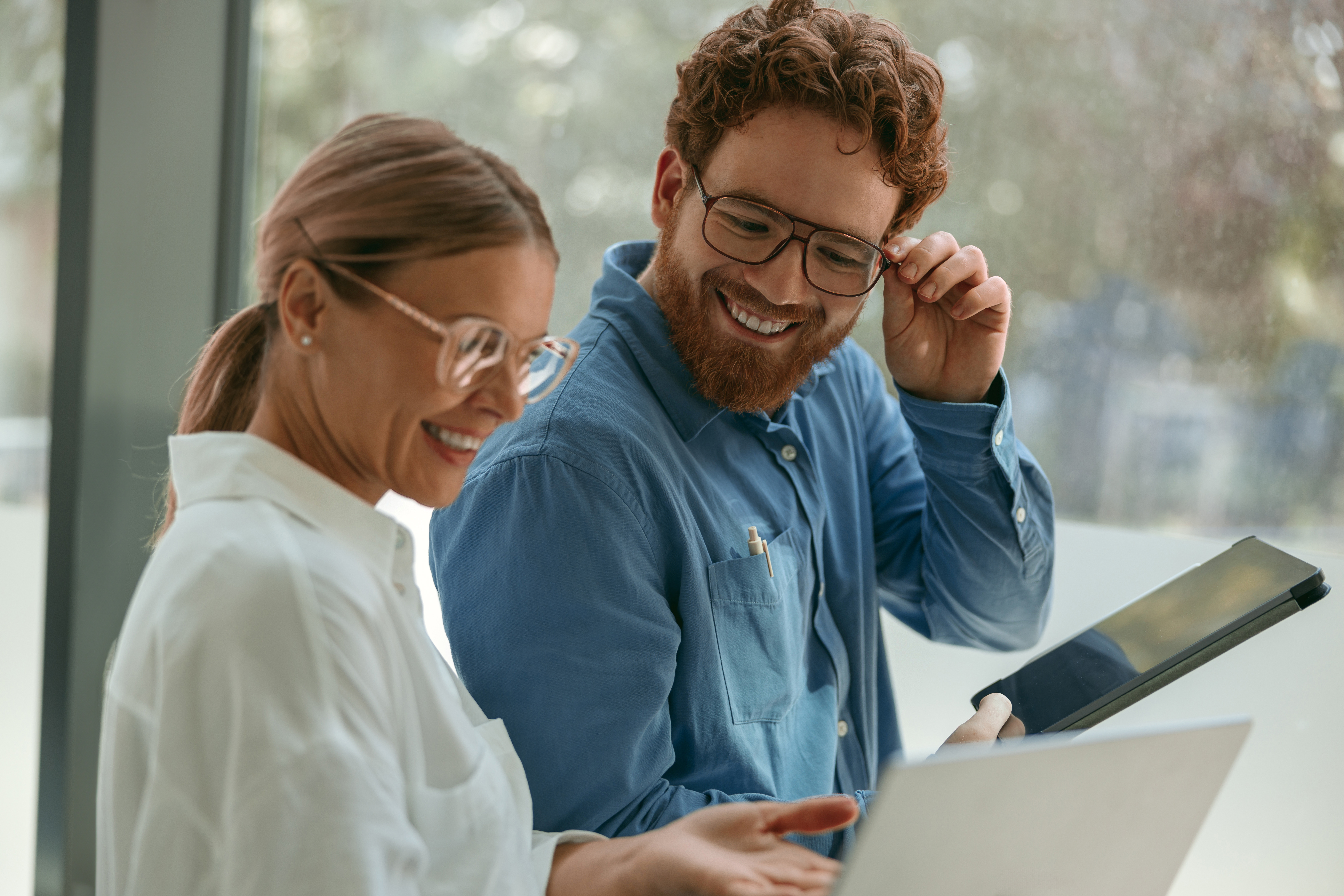 Two business colleagues working together on project in office while use laptop. High quality photo